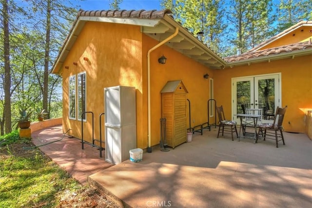 back of property with a patio, french doors, and stucco siding