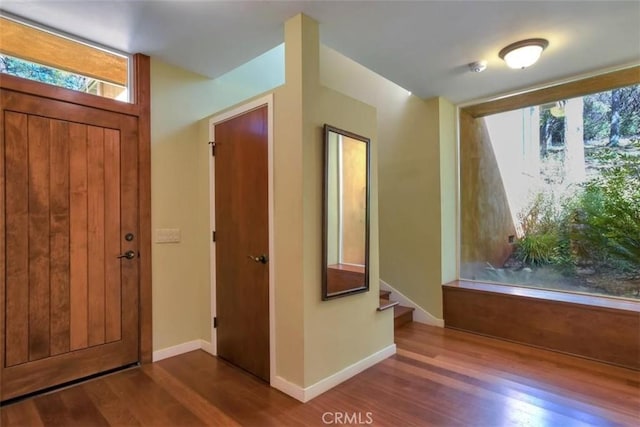 entrance foyer featuring plenty of natural light, stairway, and wood finished floors