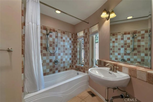 full bath featuring visible vents, a sink, shower / bath combo with shower curtain, recessed lighting, and tile patterned flooring