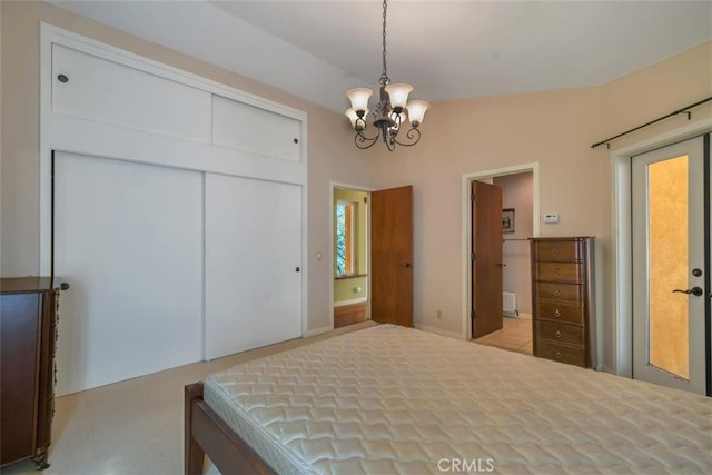 bedroom featuring a chandelier, connected bathroom, vaulted ceiling, and a closet