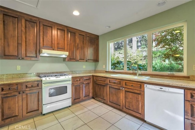 kitchen with light tile patterned floors, a sink, light countertops, white appliances, and under cabinet range hood