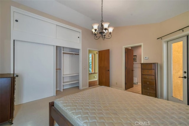 bedroom featuring a notable chandelier, vaulted ceiling, and a closet