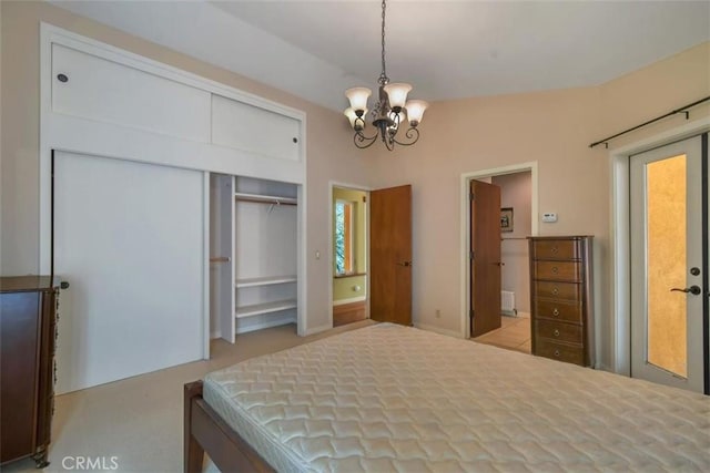 carpeted bedroom featuring a closet, an inviting chandelier, radiator heating unit, and connected bathroom