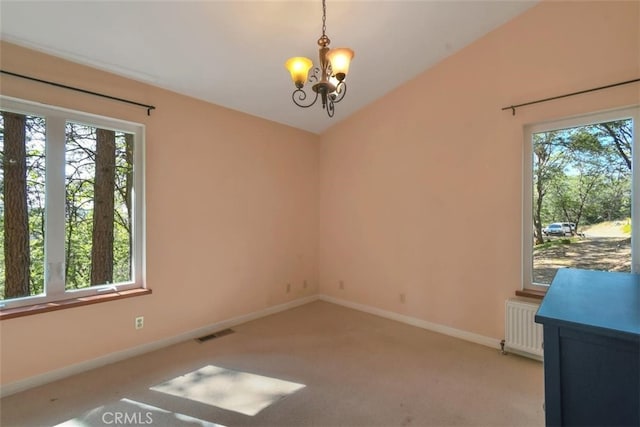 empty room with a notable chandelier, plenty of natural light, carpet floors, and radiator