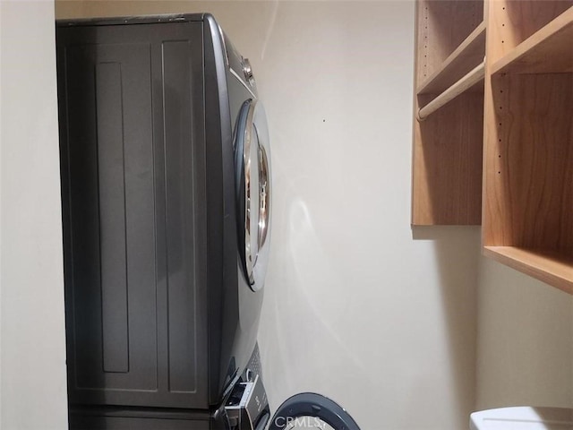 laundry room with stacked washer and clothes dryer and laundry area