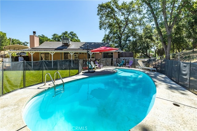 view of swimming pool featuring a patio and a yard