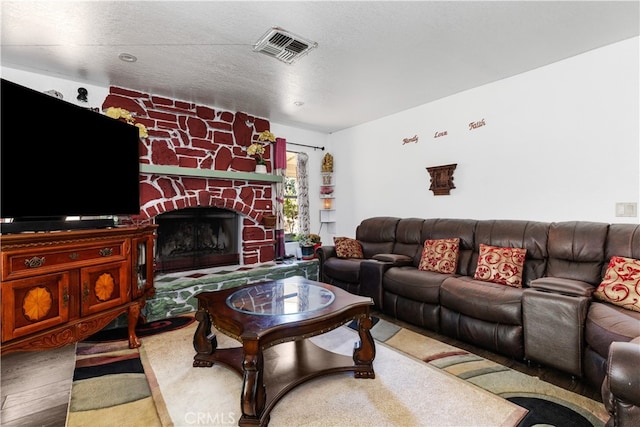 living room with a textured ceiling, a fireplace, and wood-type flooring