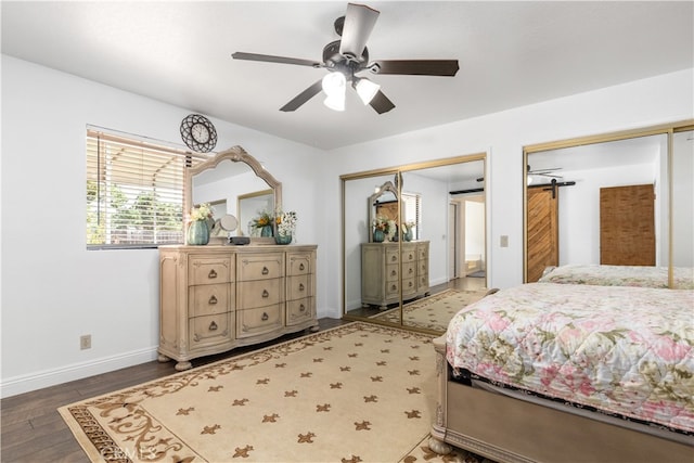 bedroom featuring a barn door, ceiling fan, and hardwood / wood-style flooring