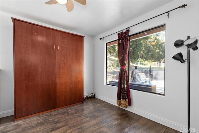 unfurnished bedroom featuring dark hardwood / wood-style floors and ceiling fan