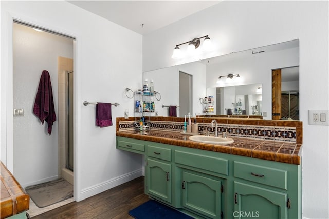 bathroom with wood-type flooring, vanity, and a shower with door