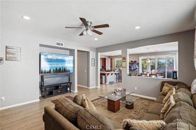 living room with light wood-type flooring and ceiling fan