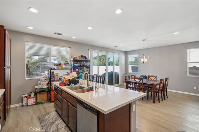 kitchen with light wood-type flooring, dishwasher, hanging light fixtures, and a healthy amount of sunlight