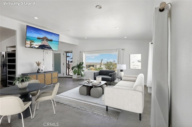 living room featuring concrete flooring and vaulted ceiling