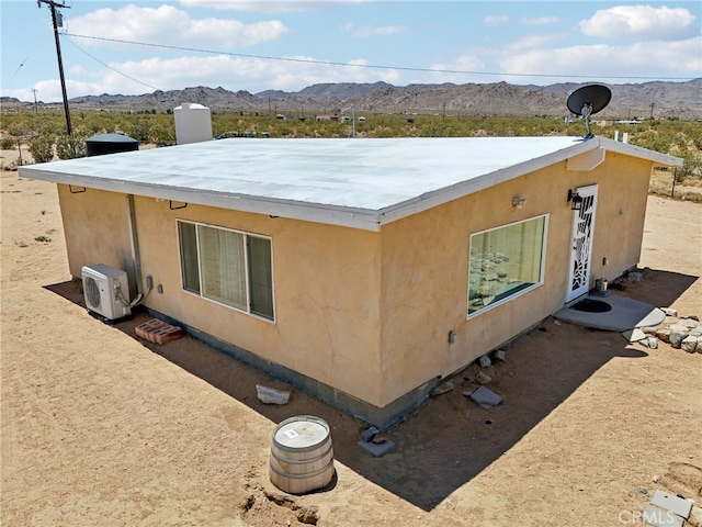 view of side of home featuring a mountain view and ac unit