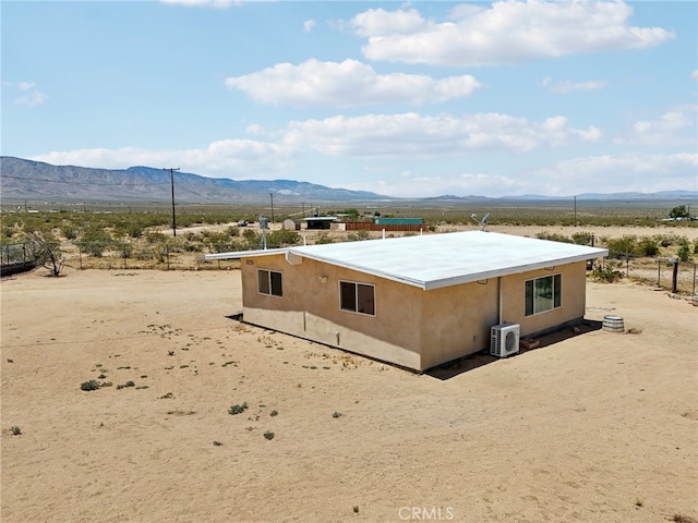 back of property with a mountain view and ac unit