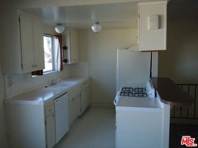 kitchen with decorative backsplash, white appliances, white cabinetry, and sink