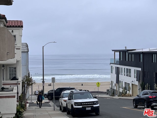 view of road with a water view and a beach view