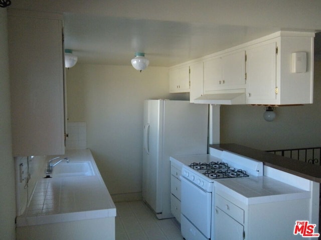 kitchen featuring tile countertops, white cabinetry, sink, and white appliances