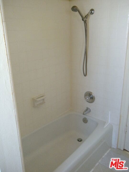 bathroom with tile patterned flooring and tiled shower / bath