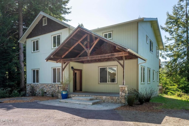 view of front facade with covered porch and stone siding