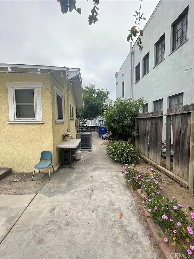 view of side of property featuring a patio and central AC