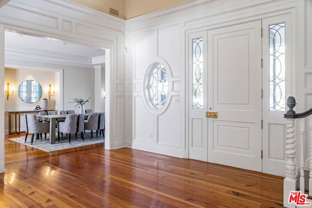 foyer with crown molding and hardwood / wood-style flooring