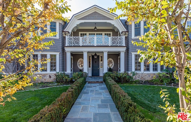 view of front of property with a front yard and a balcony