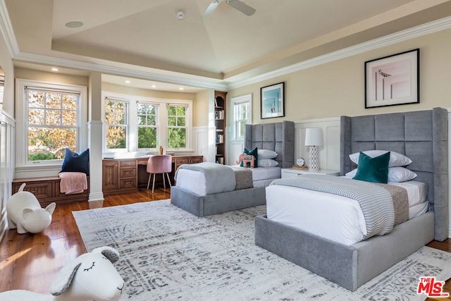 living room featuring ceiling fan, lofted ceiling, a raised ceiling, ornamental molding, and dark hardwood / wood-style flooring