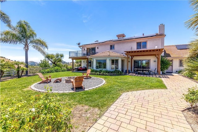 back of property featuring a pergola, a patio area, a yard, and a balcony