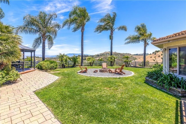 view of yard with a fire pit, a mountain view, and a patio