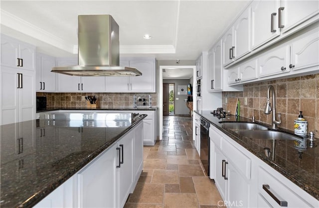 kitchen featuring island exhaust hood, white cabinets, dark stone counters, and sink