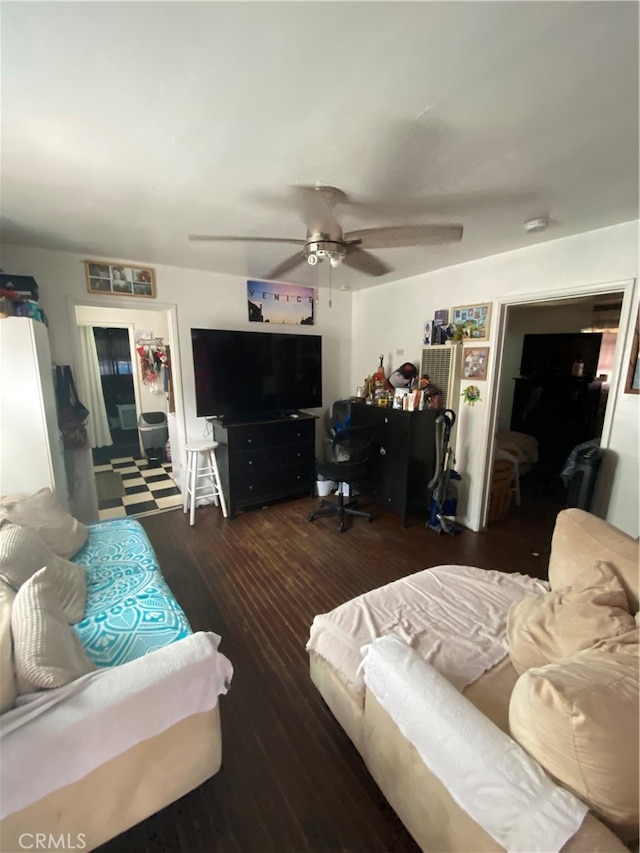 living room featuring ceiling fan and dark hardwood / wood-style floors