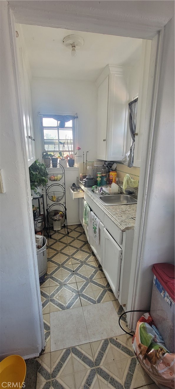 kitchen featuring white cabinetry and sink