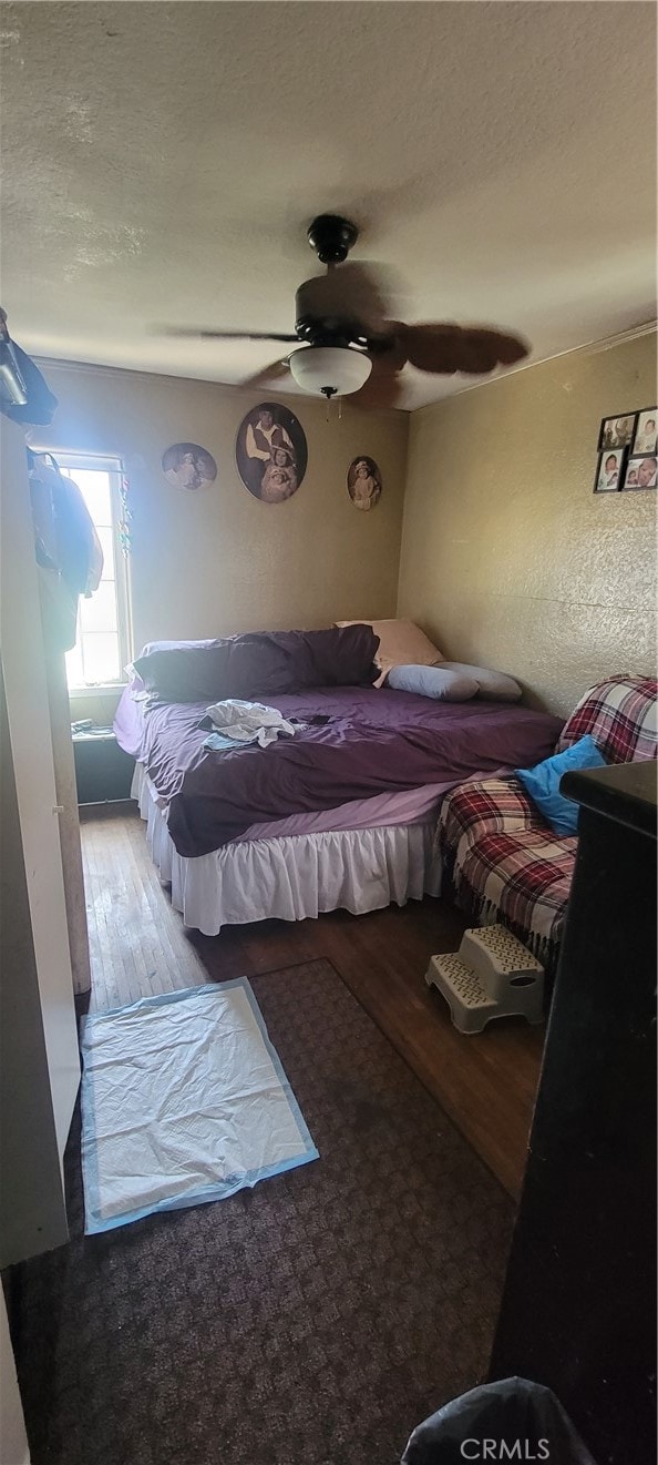 bedroom with ceiling fan and hardwood / wood-style flooring