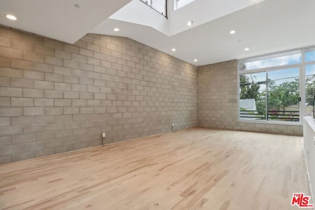 unfurnished living room featuring light hardwood / wood-style floors and a skylight