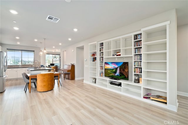 living room with sink and light hardwood / wood-style flooring