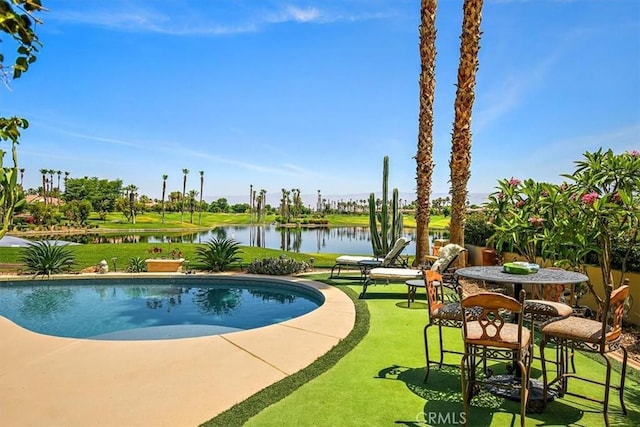 view of swimming pool featuring a yard and a water view