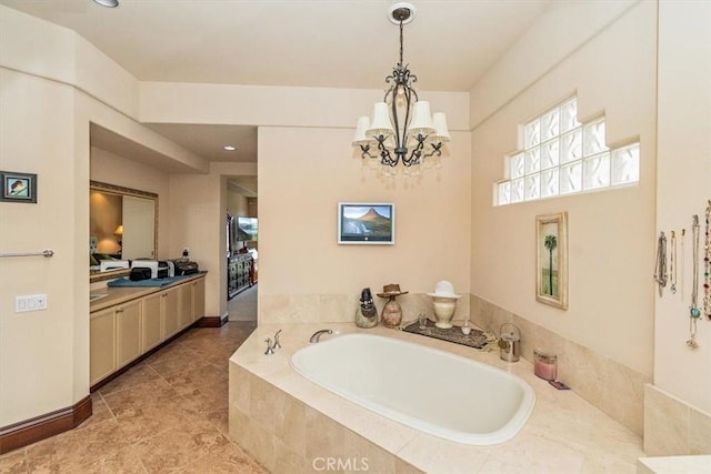 bathroom featuring a relaxing tiled tub, vanity, and a chandelier