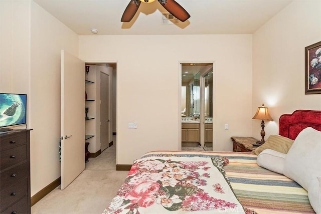 bedroom featuring light carpet, ceiling fan, ensuite bath, and baseboards