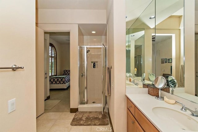 ensuite bathroom with tile patterned floors, connected bathroom, a stall shower, and vanity