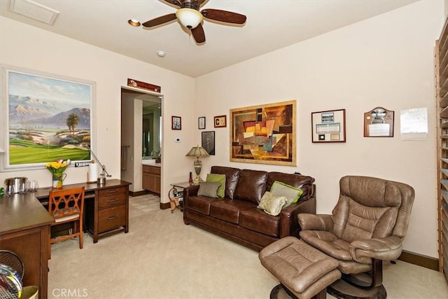 living area featuring baseboards, light colored carpet, and ceiling fan