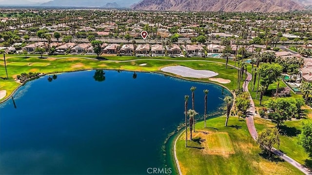 drone / aerial view with golf course view, a residential view, and a water and mountain view