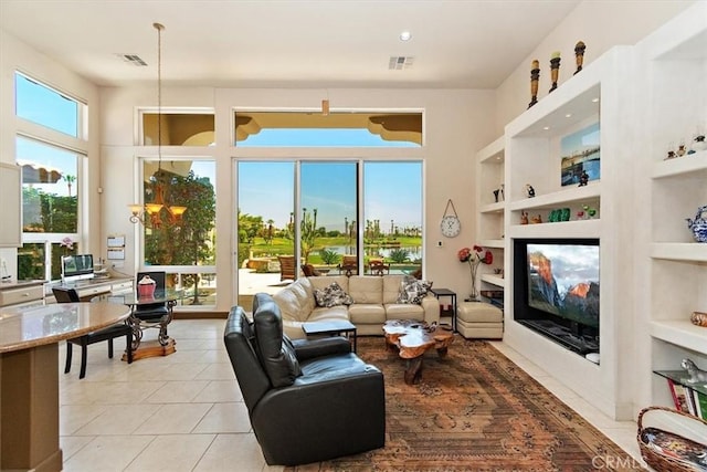 living area with light tile patterned floors, built in shelves, a healthy amount of sunlight, and a high end fireplace