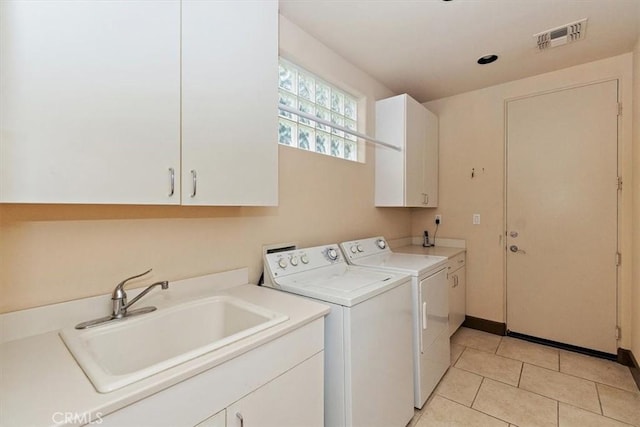 laundry area featuring visible vents, light tile patterned flooring, cabinet space, a sink, and washer and dryer