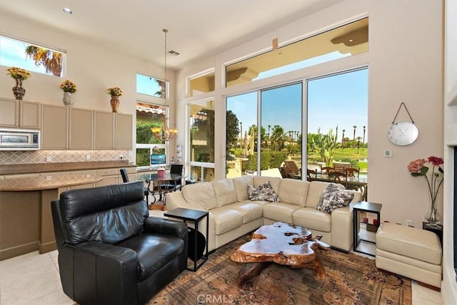 living area featuring visible vents, an inviting chandelier, and light tile patterned flooring