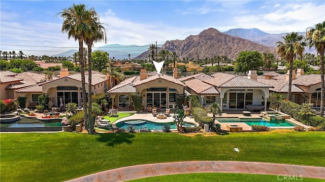 view of swimming pool with a patio area, a lawn, and a mountain view