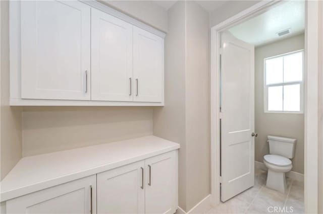 interior space with toilet and tile patterned floors