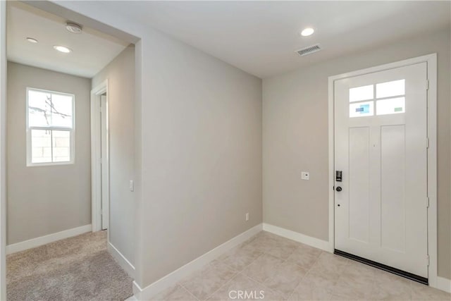 entrance foyer with light tile patterned floors and a wealth of natural light