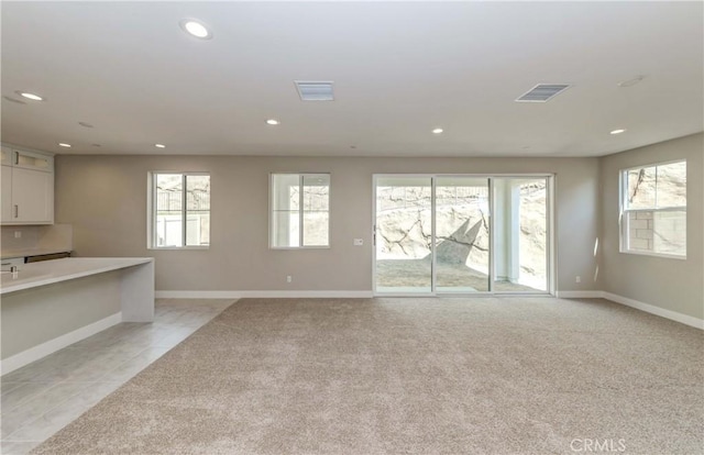 unfurnished living room with light colored carpet