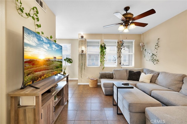 living area featuring baseboards, tile patterned flooring, visible vents, and a ceiling fan